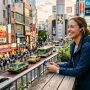 Traveler wearing AI translation earbuds on a bustling city street.